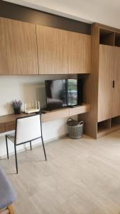 华欣Apple's La casita condo in Hua Hin的客厅配有平面电视和椅子。