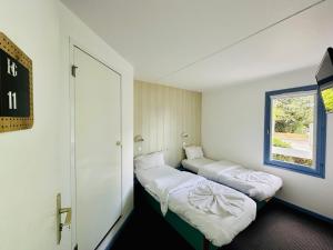 热克斯Hôtel Gex的小型客房 - 带2张床和窗户