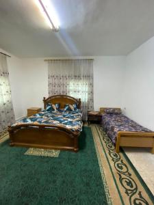 杰拉什Abuawad Rental的一间卧室配有两张床,铺有绿色地毯