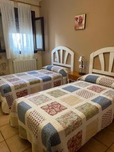 比利亚尔瓦德拉谢拉Apartamentos Los Parrales的一间设有两张床和一张桌子的房间