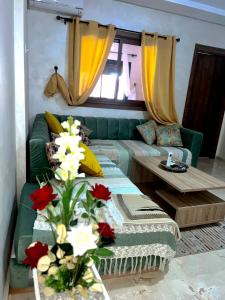 马拉喀什Luxury apartment Gueliz (2 min walk from Train Station)的客厅配有绿色沙发和桌子