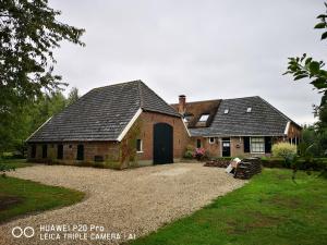 EpseThe nicest farmhouse in Holland!的砖房,有黑色的门和院子