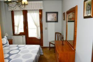 阿维莱斯Puerta la Villa的一间卧室配有一张床、梳妆台和镜子