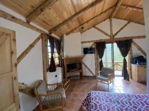 昆卡The Hideout- A Cabin in Nature; 25 min from Cuenca的一间卧室,卧室内配有一张床和椅子
