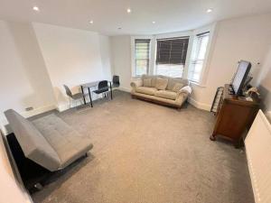 萨顿Spacious 1-bedroom Flat in Sutton (South London)的客厅配有沙发和桌子