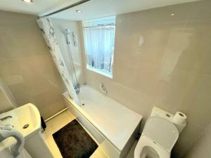 萨顿Spacious 1-bedroom Flat in Sutton (South London)的一间带两个卫生间、淋浴和盥洗盆的浴室
