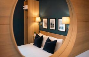 都柏林凯尔特旅馆客栈餐厅和酒吧的镜子反射着一间卧室,配有黑色和白色枕头