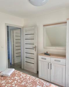 内克瑟Apartamenty Golf Dyndeby的卧室配有大镜子和白色橱柜