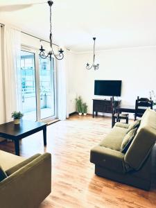 波兹南普瑞兹莱库公寓的客厅配有沙发、桌子和钢琴