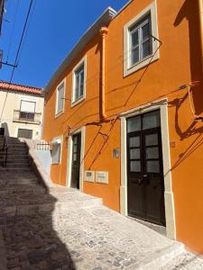 塞图巴尔Holiday Setúbal Loft的一座橙色的建筑,在街道旁设有楼梯