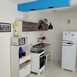 维拉维尔哈Apartamento Itagarça - Praia de Itaparica的厨房配有白色家电和蓝色天花板