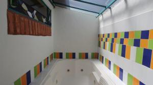 莱瓦镇阿克利斯套房酒店的浴室设有色彩缤纷的瓷砖和浴缸。