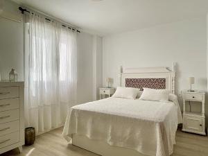 隆达Apartamento Ronda Centro的白色卧室配有白色的床和梳妆台