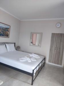 耶奥伊乌波利斯Yannis apartments的一间卧室配有一张带白色床单和镜子的床