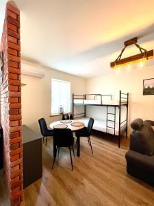苏普拉希尔Apartament Centrum的客厅配有桌椅和一张双层床。