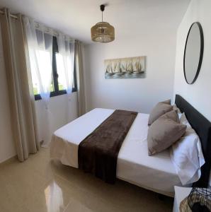 迈阿密普拉特亚Evasion的一间卧室配有一张带白色床单和镜子的床