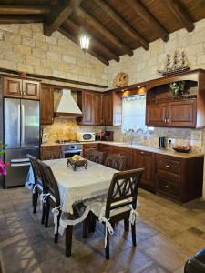 MaroniParadise Traditional House的厨房配有桌椅和冰箱。