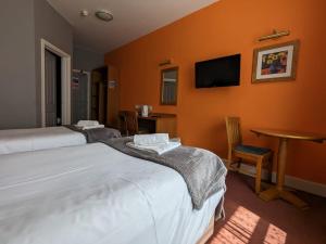 剑桥德比伯爵酒店的酒店客房设有两张床和一台墙上的电视。