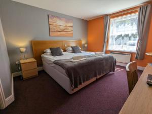 剑桥德比伯爵酒店的一间卧室设有一张大床和一个窗户。