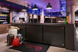 埃森Moxy Essen City的一间酒吧,上面有黑色的柜台,上面有红色的袋子