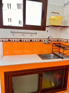 拉巴特Appartement Cosy quartier chic de Rabat的带水槽的厨房台面和2扇窗户