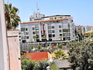 拉巴特Appartement Cosy quartier chic de Rabat的一座白色的大建筑,前面有棕榈树