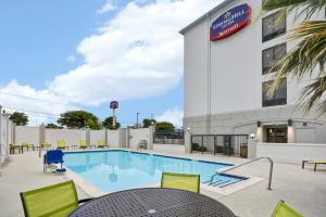 圣安东尼奥SpringHill Suites by Marriott San Antonio Medical Center/Northwest的大楼旁的一个带桌椅的游泳池
