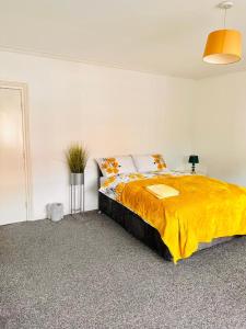 利兹Private Room close to Leeds University and City centre的一间卧室配有一张带黄色毯子的大床