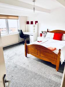 利兹Private Room close to Leeds University and City centre的一间卧室配有一张大木床和一张书桌