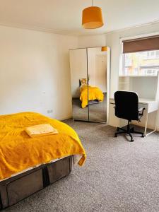 利兹Private Room close to Leeds University and City centre的一间卧室配有一张床、镜子和椅子