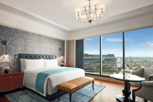 浦那The Ritz-Carlton, Pune的一间卧室设有一张床和一个大窗户