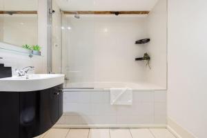 伦敦Wild Roses Serviced Apartments - ExCel Warehouse 2的白色的浴室设有水槽和淋浴。