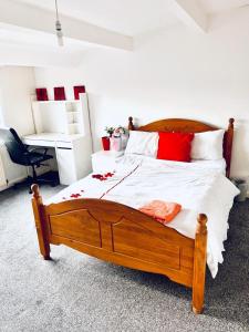 利兹Private Room close to Leeds University and City centre的一间卧室配有一张带红色枕头的大型木制床。