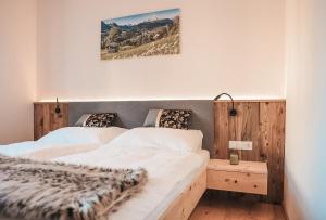 菲根AlpenLuxus' VERONIKAS Relax & Family Suite with sun terrace and car park的卧室配有两张床,墙上挂着一幅画