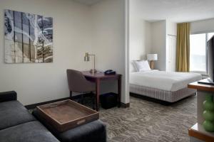 丹伯里丹伯里春季山丘套房酒店的配有一张床和一张书桌的酒店客房