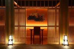 Jozankei定山溪翠山亭酒店的一张桌子和椅子,位于带两个灯的房间