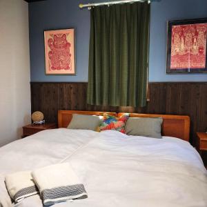 饭山市斑尾山山林小屋的卧室配有一张大白色床和窗户