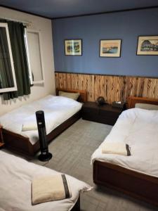 饭山市斑尾山山林小屋的一间卧室设有两张床和蓝色的墙壁