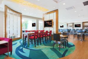 圣何塞圣何塞机场春季山丘套房酒店的一间设有红色椅子和桌子的用餐室以及窗户。
