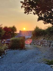 兰贝德Ty Gwennol near Gilfach Goch的落在房子和碎石路上的日落