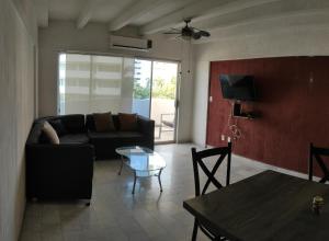 阿卡普尔科Fresca estancia en zona Dorada con Alberca/Playa!的客厅配有沙发和桌子