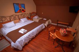 普孔Hotel Inti Kuyen Plaza的酒店客房设有一张大床和一张桌子。