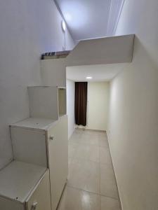 迪拜SKY 9 Hostel的一间空房间,设有白色的墙壁和小冰箱