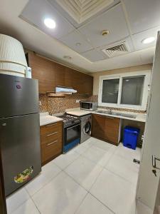 迪拜SKY 9 Hostel的厨房配有不锈钢冰箱和洗碗机