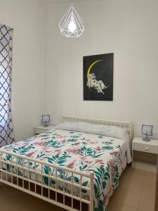 吉诺萨滨海Il mare che ti Puglia的一间卧室配有一张带花卉棉被的床