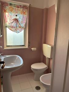 吉诺萨滨海Il mare che ti Puglia的一间带卫生间、水槽和窗户的浴室