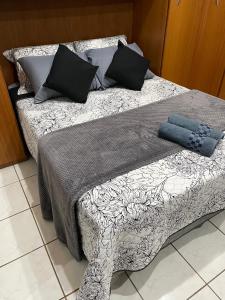 圣保罗Suíte Próxima Ao Metrô Penha !!!的一张配有黑白床单和枕头的床