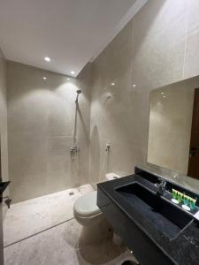 麦地那سويت إم للأجنحة الفندقية的浴室配有卫生间、盥洗盆和淋浴。