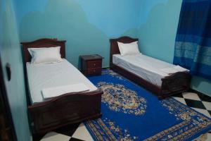 瓦尔扎扎特Riad Dar Fadma的蓝色墙壁客房的两张床