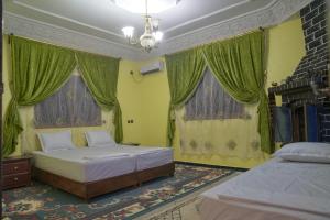 瓦尔扎扎特Riad Dar Fadma的一间卧室设有两张床和绿色窗帘